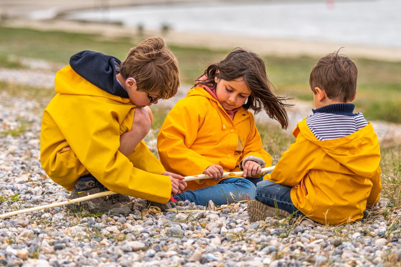 Baie de Somme : enfants en cirés sur la plage de galets