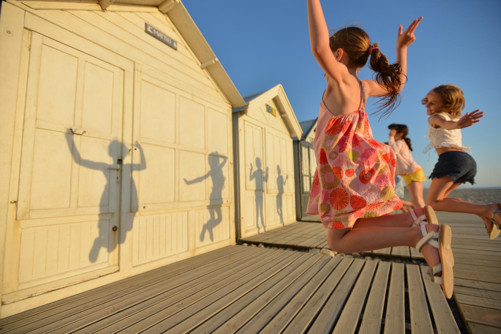 Cayeux-sur-Mer : fillettes sautant sur les planches devant les cabines de plage