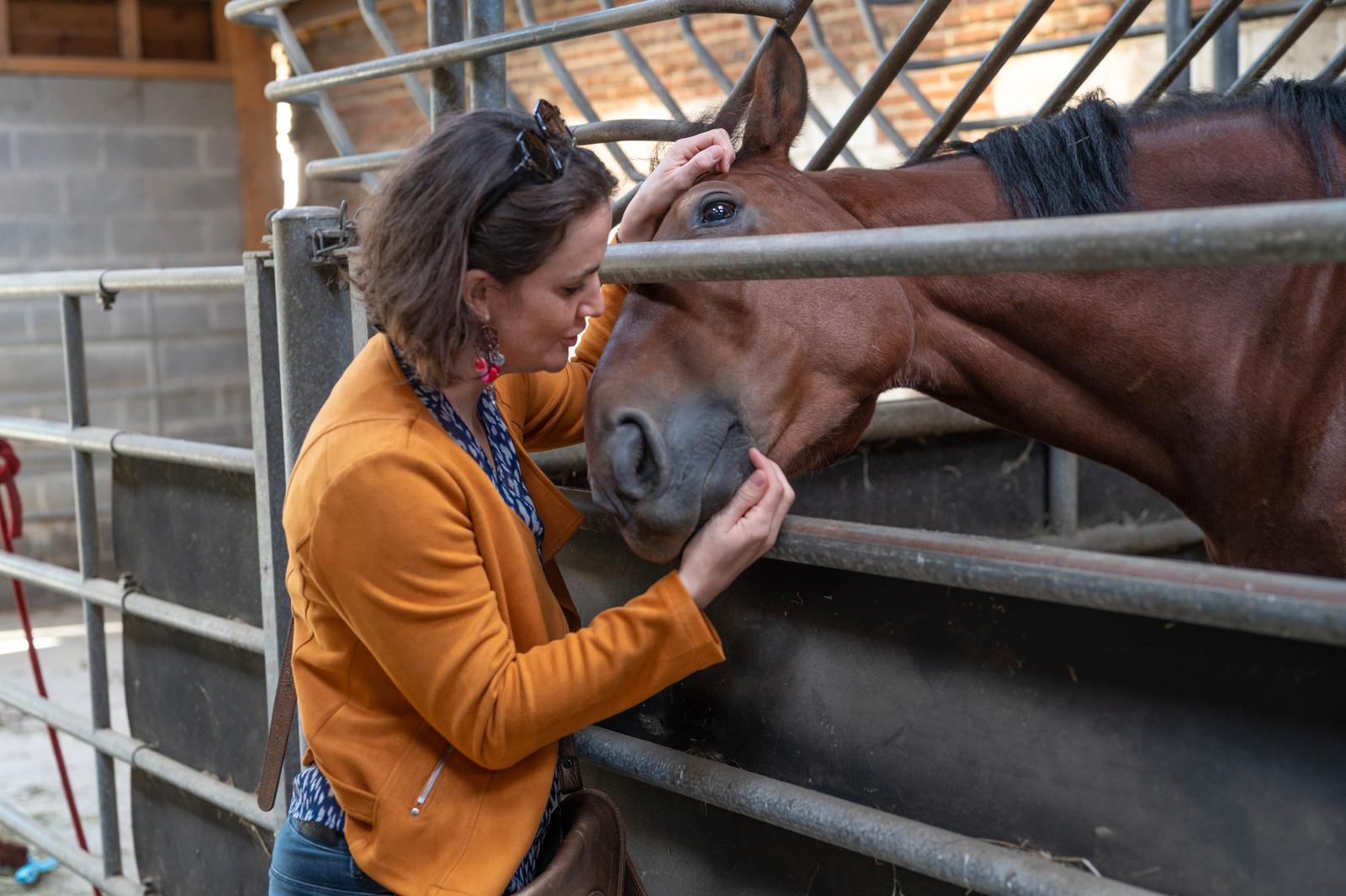 Beauchamps : domaine du Lieu Dieu, femme caressant un cheval