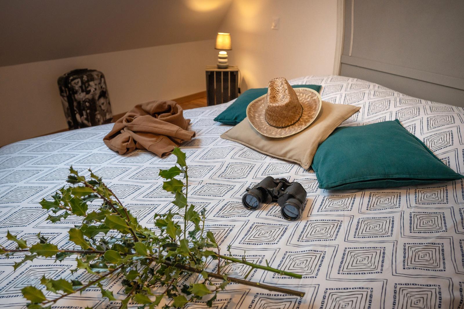 Bouillancourt-en-Séry : houx, jumelles, chapeau posé sur le lit au gîte de Séry