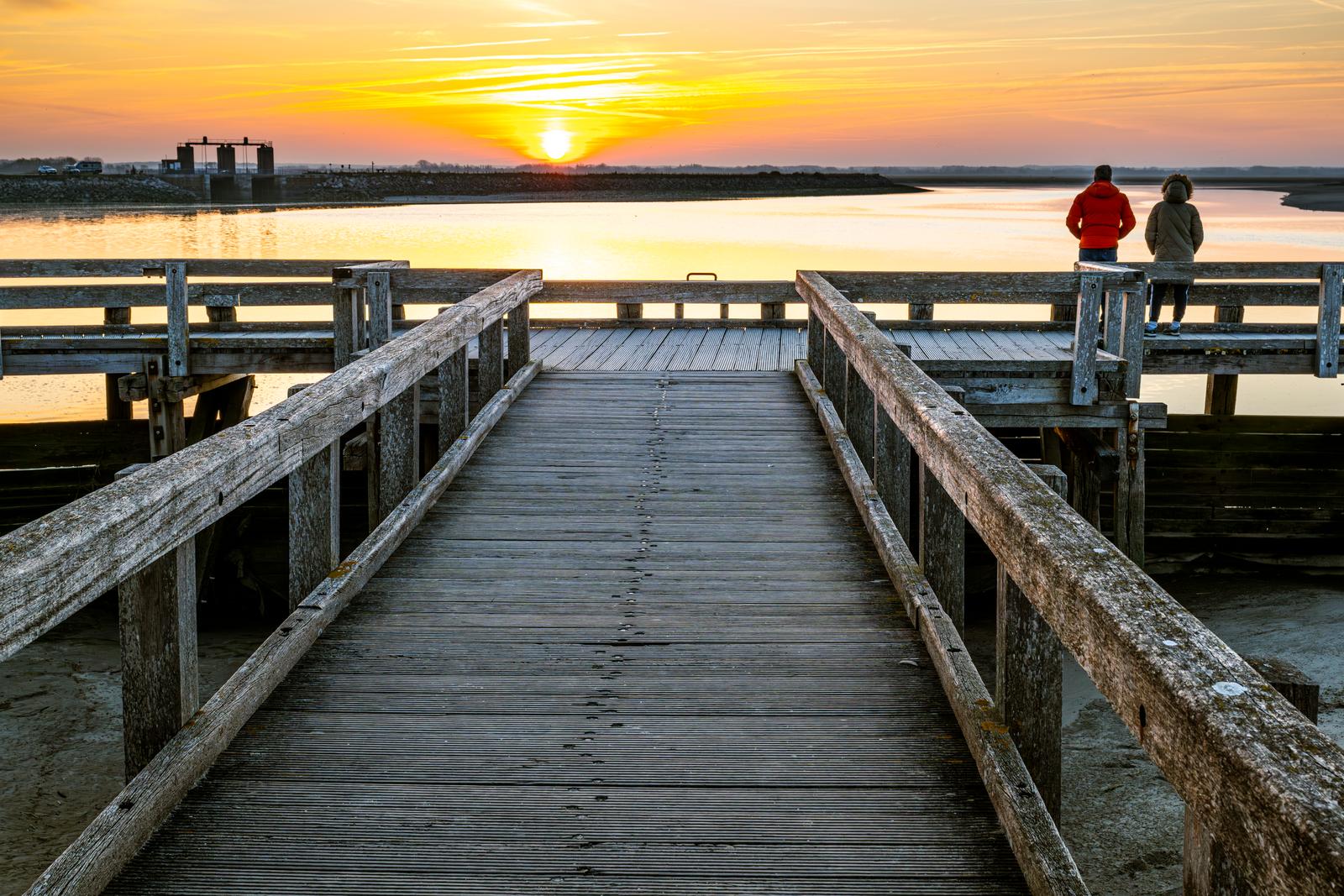 Le Crotoy : couple sur un ponton en hiver au soleil couchant