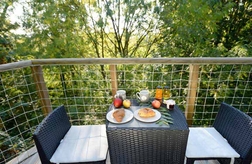 Petit-déjeuner en terrasse avec vue sur la canopée au Château des Tilleuls