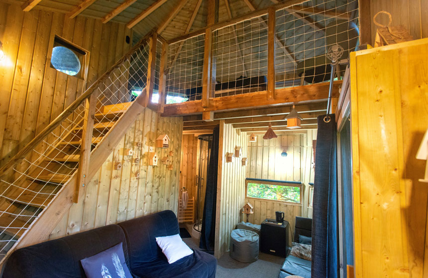 L'espace salon de votre cabane Le Nichoir avec votre lit en mezzanine